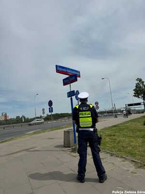 Policjant ruchu drogowego w żółtej kamizelce przy skrzyżowaniu ulic Warszawie.