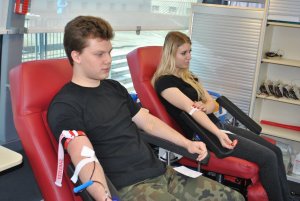 Młodzież siedząca na fotelu podczas poboru krwi
