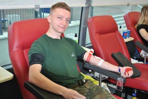 Młody mężczyzna na fotelu podczas pobierania krwi