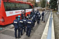 Policjantki i Policjantki w mundurach wchodzący do autobusu poboru krwi