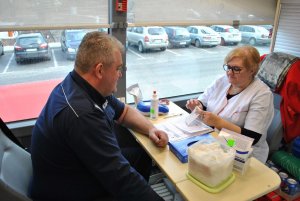 Umundurowany Policjant z pielęgniarką podczas wypełniania formularzy