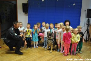 Zadowolone dzieci z psem i policjantem