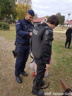 Chłopak przymierzający kamizelkę policyjną