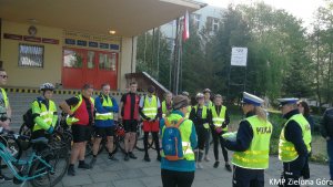 fotografia kolorowa, policjanci rozmawiają z grupą rowerzystów