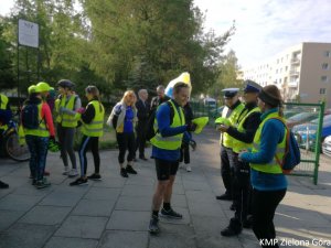 fotografia kolorowa, policjanci ruchu drogowego rozmawiają z grupą rowerzystów