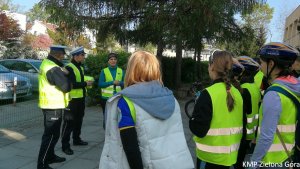 fotografia kolorowa, policjanci ruchu drogowego rozmawiają z grupą rowerzystów