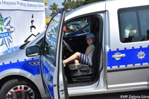 Chłopiec siedzący w radiowozie na miejscu kierującego pojazdem