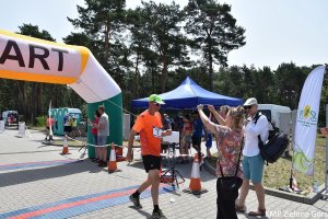 Mężczyzna, któremu wręczają medal po ukończeniu biegu