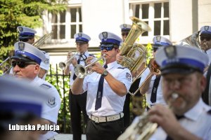 Zdjęcie reprezentacyjnej orkiestry policyjnej z policjantem trzymającym trąbkę po środku
