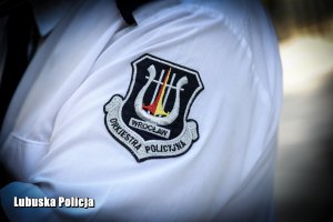 Zdjęcie przyszywki herbu orkiestry policyjnej Wrocławia na ramieniu policjanta