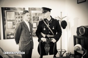 Czarno- białe zdjęcie policjanta ubranego w stary mundur i mężczyzny ubranego w garnitur