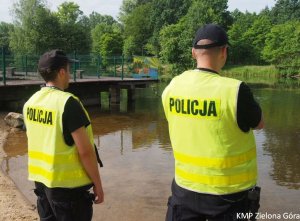 Dwóch policjantów stojących nad jeziorem