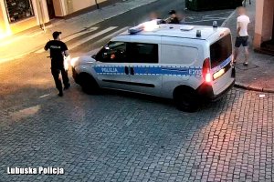 Policjanci wychodzący z radiowozu stojącego na ulicy