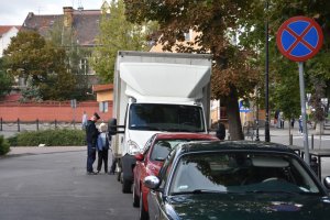 Policjant spisuje nieprawidłowo zaparkowany samochód