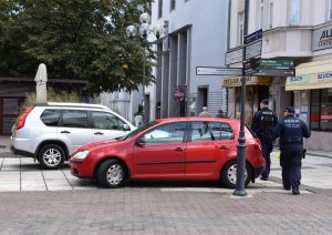 Policjanci patrolują teren deptaku w Zielonej Górze i kontrolują nieprawidłowo stojące dwa samochody