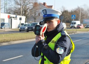 Policjant Ruchu Drogowego mierzy prędkość samochodu