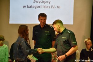 Policjanci wręczają dyplom dziewczynce