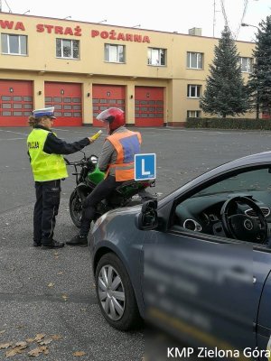 Policjantka Ruchu Drogowego sprawdza stan trzeźwości kursanta nauki jazdy na motocyklu