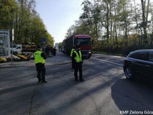 Policjanci pilnują bezpieczeństwa na drodze koło cmentarza