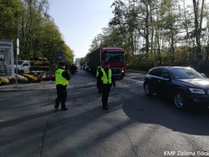 Policjanci pilnują bezpieczeństwa na drodze koło cmentarza