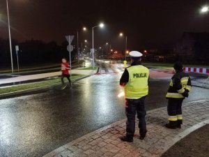 Policjant i strażak zabezpieczają rondo na trasie biegu