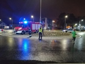 Policjant i strażak zabezpieczają rondo na trasie biegu