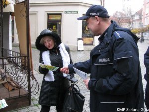 Policjant rozdający ulotki o &quot;Bezpiecznym Seniorze&quot;