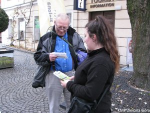 Kobieta rozdająca ulotki seniorom