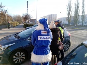 Polikołaj i Policjant nagradzający za dobra jazdę kierowce samochodu