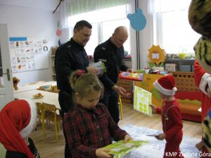 Policjanci z dziećmi z odblaskowymi naklejkami