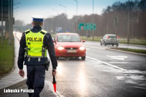 Policjant z kamizelce odblaskowej i lizakiem