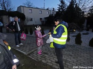 Policjanta rozdająca odblaski dzieciom