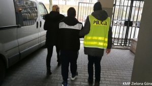 Policjanci prowadza zatrzymanego mężczyznę