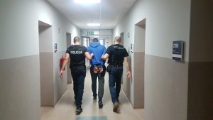 Policjanci z mężczyzną w kajdankach