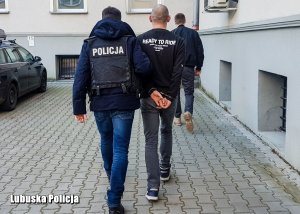 Policjanci prowadzą zatrzymanego 29-letniego mężczyznę