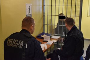 Dwóch policjantów podczas rozmowy z zatrzymanym mężczyzną