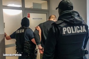 Policjanci prowadzący oskarżonego mężczyznę