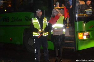 Policjant z kobietą w blond włosach podczas kontroli autobusów.