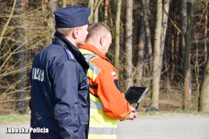 Policjant ze strażakiem sterującym dronem.