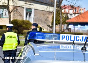 Policjanci z radiowozem obok biblioteki