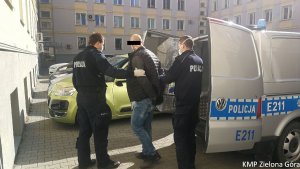 Policjanci prowadzący poszukiwanego 36-latka. w kajdankach