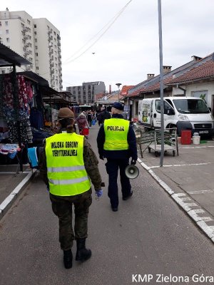 Policjant i Pani z wojska idący z megafonem