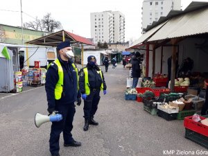 Policjant i Strażnik Miejski z megafonem na targu