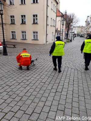 Strażak i straż miejska na deptaku z dronem