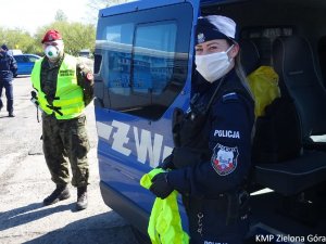 Zdjęcie patrolu przy samochodzie Żandarmerii Wojskowej.