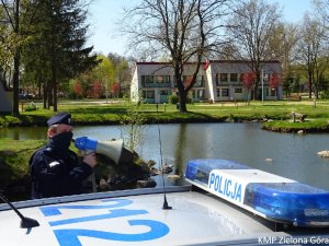 Policjant trzymający megafon w ręku.