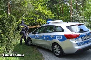 Policjant przy radiowozie policyjnym.