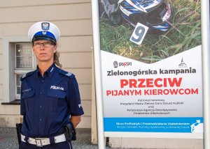 Policjantka stojąca przy bilbordzie