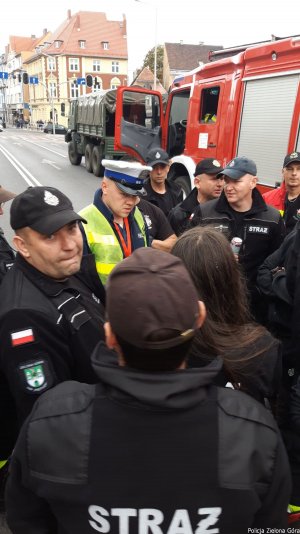 Policjant rozmawia ze strażakami