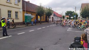 Policjant wskazujący drogę kolarzom.